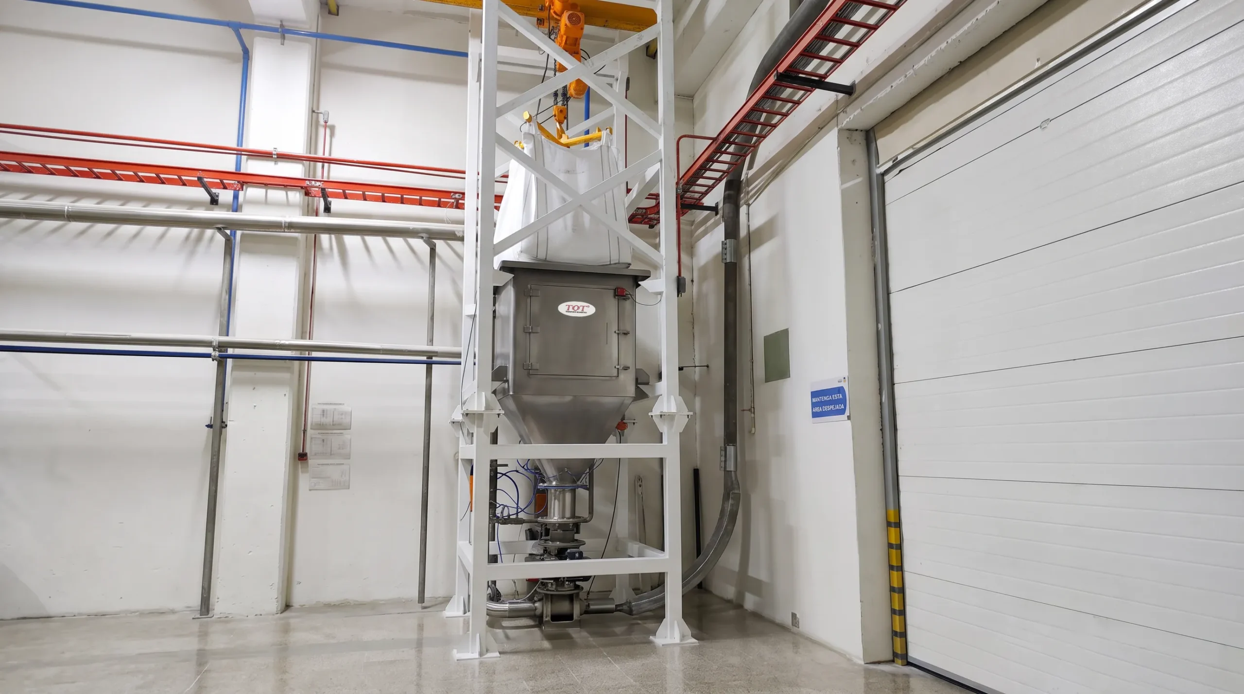 Estación de descarga de Big Bag en acero inoxidable acoplada a una válvula rotativa para la extracción mediante transporte neumático de sólidos a granel en sala limpia.